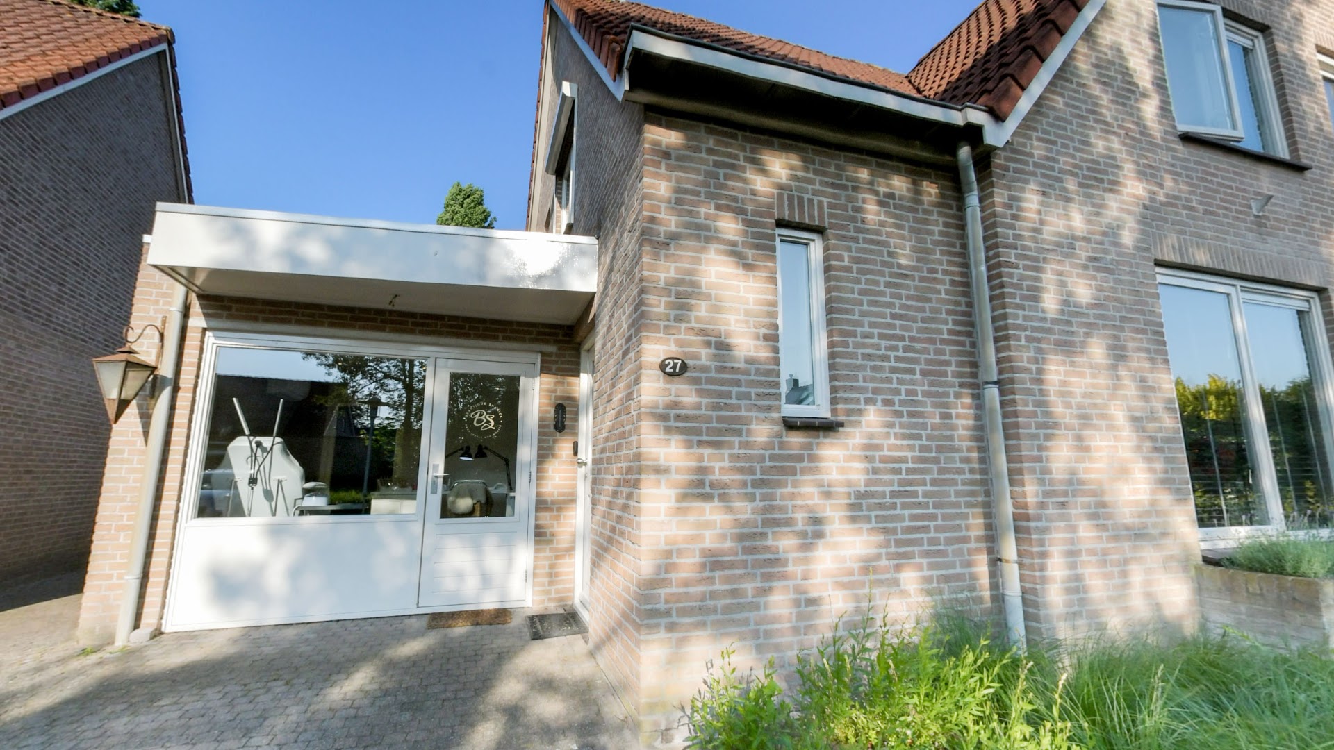 De ingang van Beautique Shanice aan de Hofdreven in Rijsbergen, met het logo op de deur